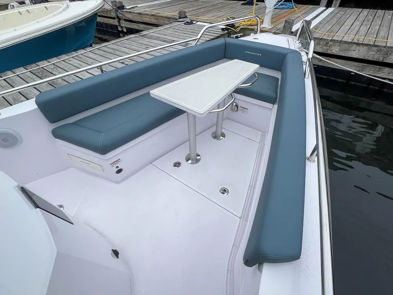 Slide: The Image of 2022 Axopar 28 Cabin Aft Cabin boat with blue seating and white table. - 6