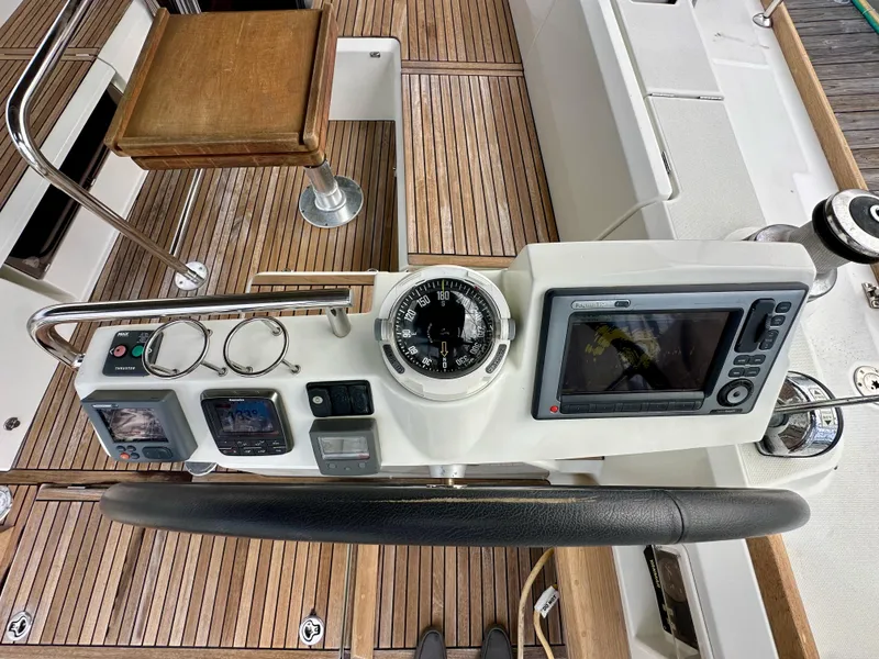 Slide: The Image of Cockpit of 2012 Beneteau Sense 43 sailboat with navigation instruments and wooden flooring. - 15