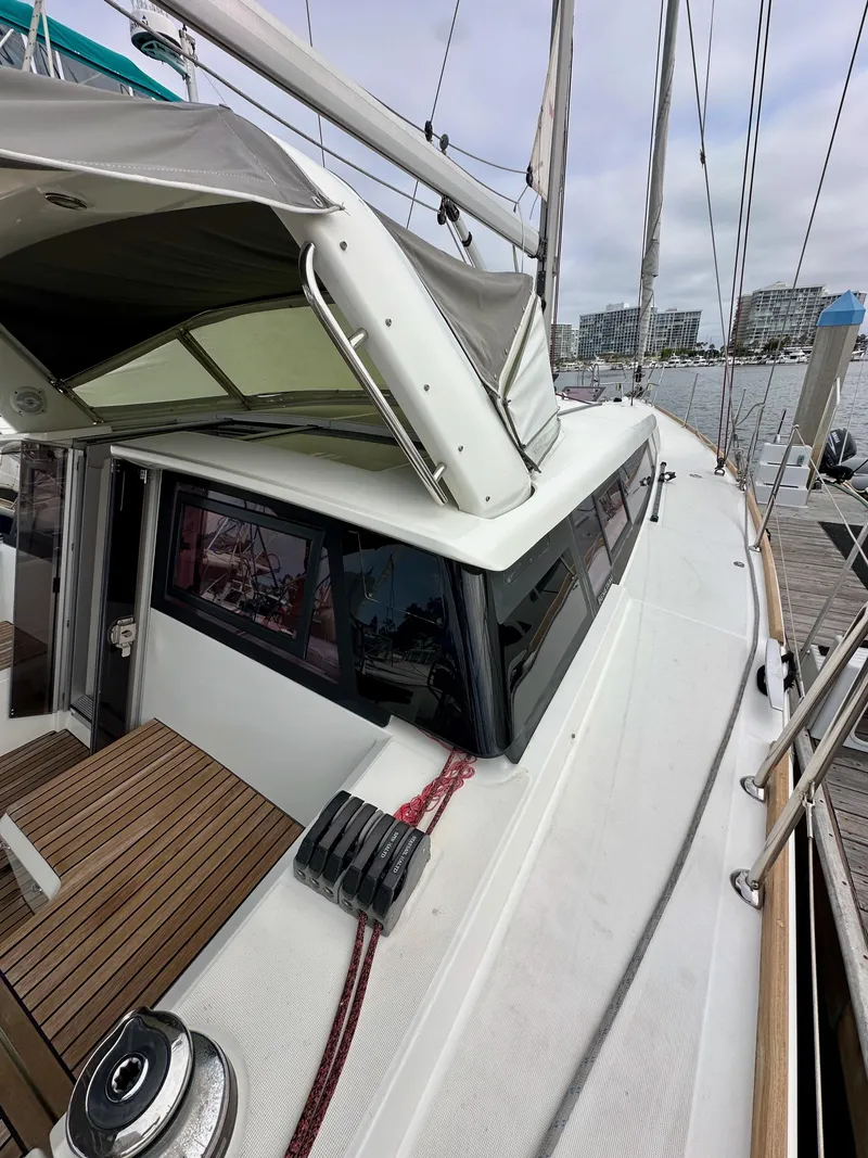 Slide: The Image of 2012 Beneteau Sense 43 sailboat docked, featuring sleek design and spacious deck. - 19