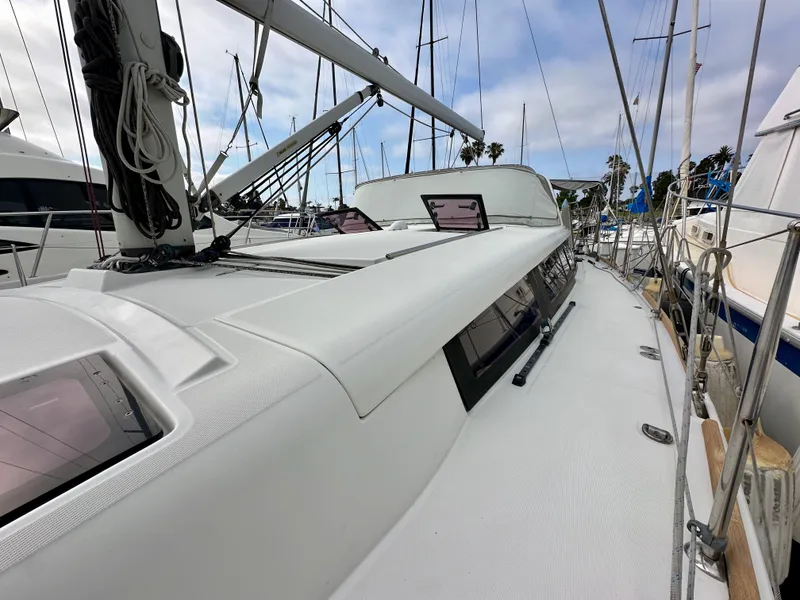 Slide: The Image of 2012 Beneteau Sense 43 sailboat deck with rigging and hatches in marina setting. - 28