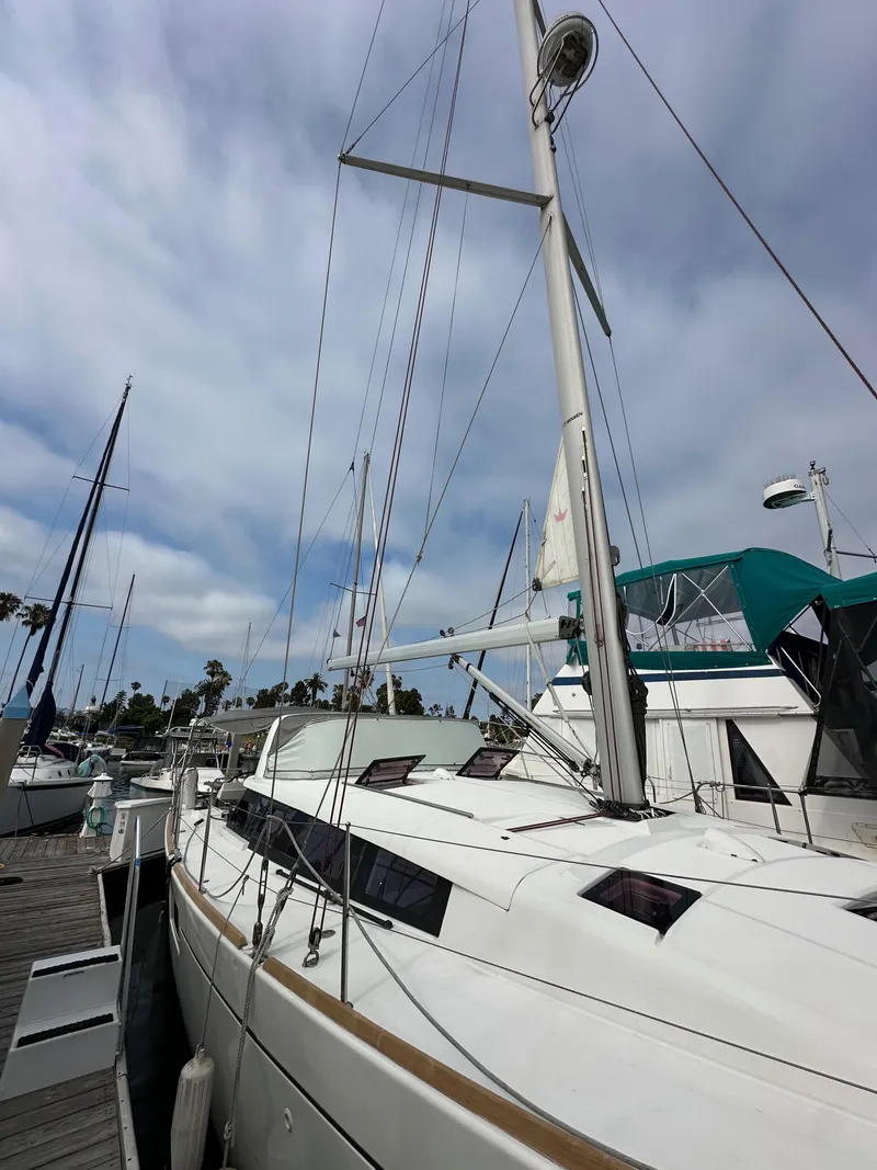 Slide: The Image of 2012 Beneteau Sense 43 sailboat docked at marina under cloudy sky. - 3