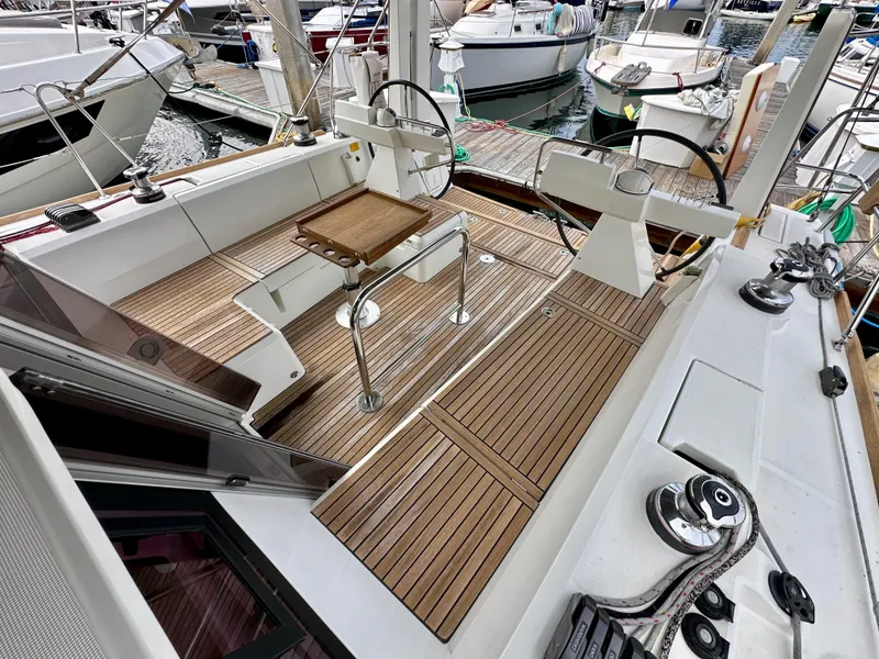 Slide: The Image of 2012 Beneteau Sense 43 yacht cockpit with wooden deck and steering wheel at marina. - 32