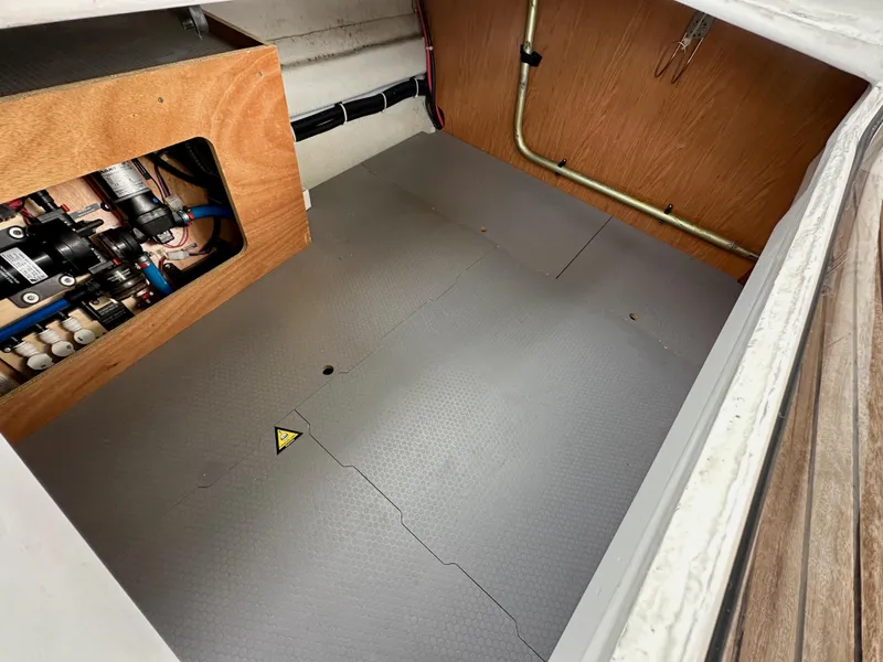 Slide: The Image of Interior view of a 2012 Beneteau Sense 43 yacht's storage compartment with visible wiring and equipment. - 36