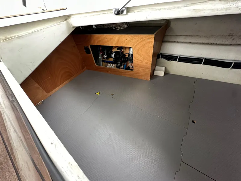 Slide: The Image of Storage compartment of a 2012 Beneteau Sense 43 sailboat, featuring a wooden panel and equipment. - 37