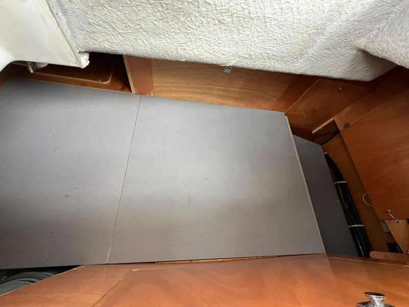 Slide: The Image of Interior view of a 2012 Beneteau Sense 43 yacht, showcasing wooden cabinetry and flooring. - 42