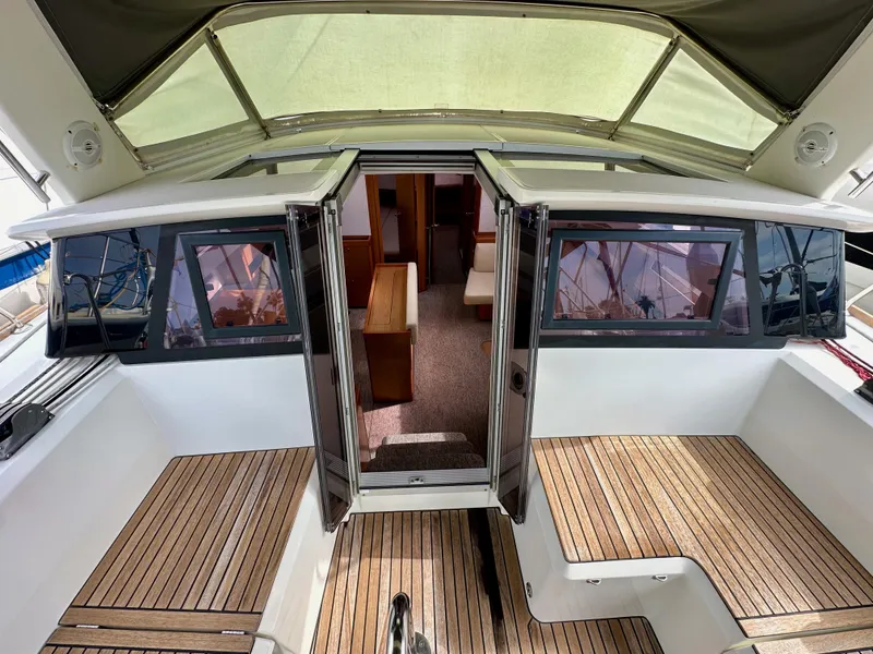 Slide: The Image of 2012 Beneteau Sense 43 yacht interior with wooden deck and open cabin doors. - 47