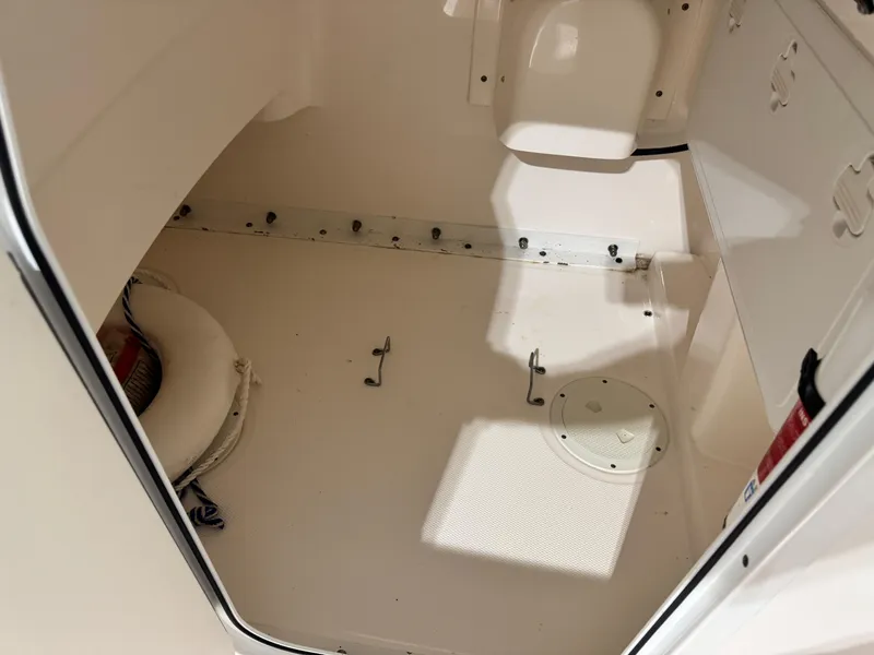Slide: The Image of Interior of 2014 Everglades 243 CC boat, featuring storage space and safety equipment. - 15