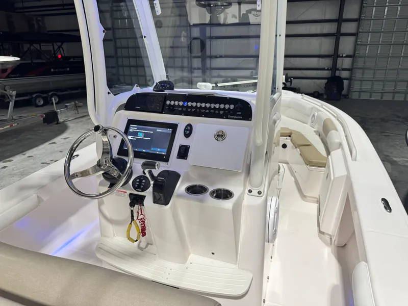 Slide: The Image of 2014 Everglades 243 CC boat interior with steering console and seating in a garage. - 20