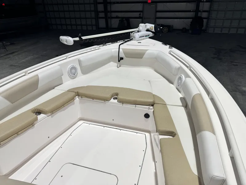 Slide: The Image of 2014 Everglades 243 CC boat interior with cushioned seating and trolling motor in a garage. - 21
