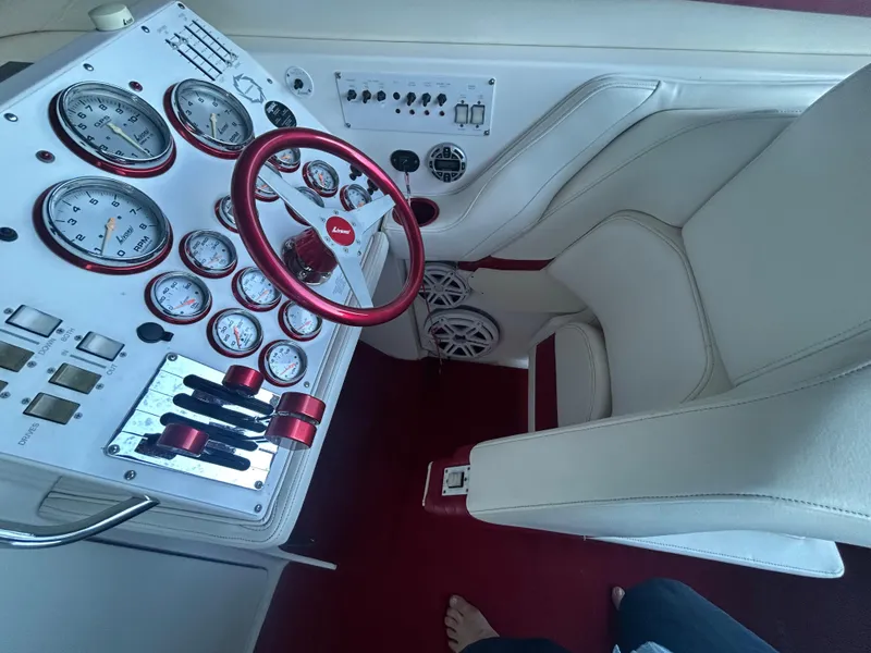 Slide: The Image of 2005 Fountain 42 Executioner boat cockpit with gauges, red steering wheel, and white seating. - 10