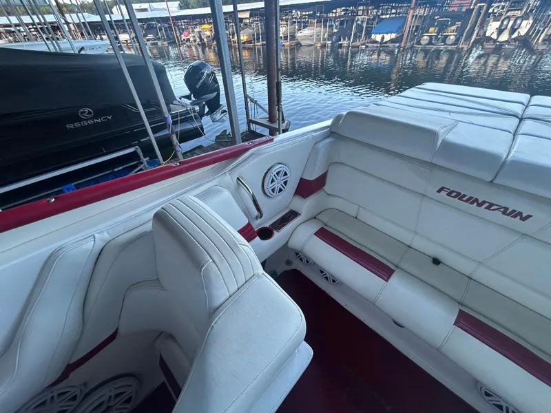 Slide: The Image of 2005 Fountain 42 Executioner boat interior with white and red seating at a marina. - 11