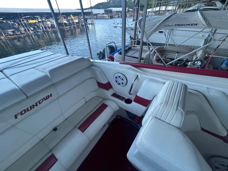 Slide: The Image of 2005 Fountain 42 Executioner boat interior with white and red seating at a marina. - 13
