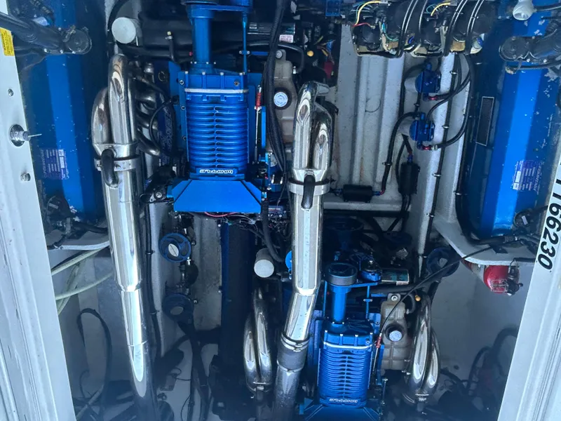 Slide: The Image of Engine compartment of a 2005 Fountain 42 Executioner boat, featuring blue and chrome components. - 16