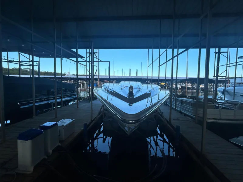 Slide: The Image of 2005 Fountain 42 Executioner boat docked in a marina under a covered structure. - 3