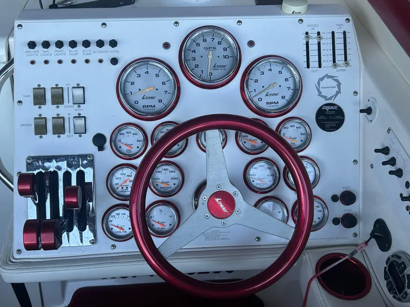 Slide: The Image of Control panel of a 2005 Fountain 42 Executioner boat with gauges and steering wheel. - 7