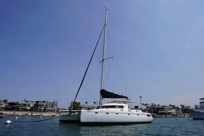 Slide: The Image of Sailing catamaran Fountaine Pajot Venezia 42, 1995, anchored near coastal homes. - 0
