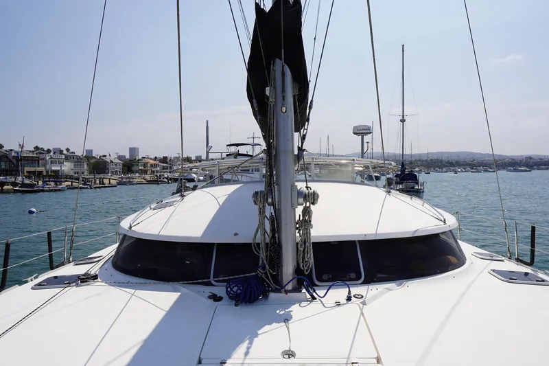 Slide: The Image of 1995 Fountaine Pajot Venezia 42 catamaran docked in a marina with coastal view. - 15