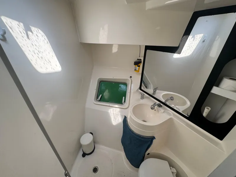 Slide: The Image of Bathroom interior of 1995 Fountaine Pajot Venezia 42 catamaran, featuring sink, mirror, and window. - 27