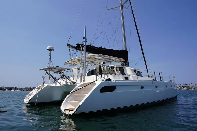 Slide: The Image of Fountaine Pajot Venezia 42 catamaran, 1995 model, anchored on calm water under clear blue sky. - 3