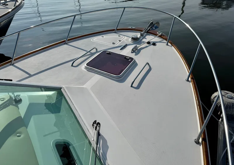 Slide: The Image of 2009 Hunt Yachts Harrier 29 boat deck with railing and hatch, docked on calm water. - 10