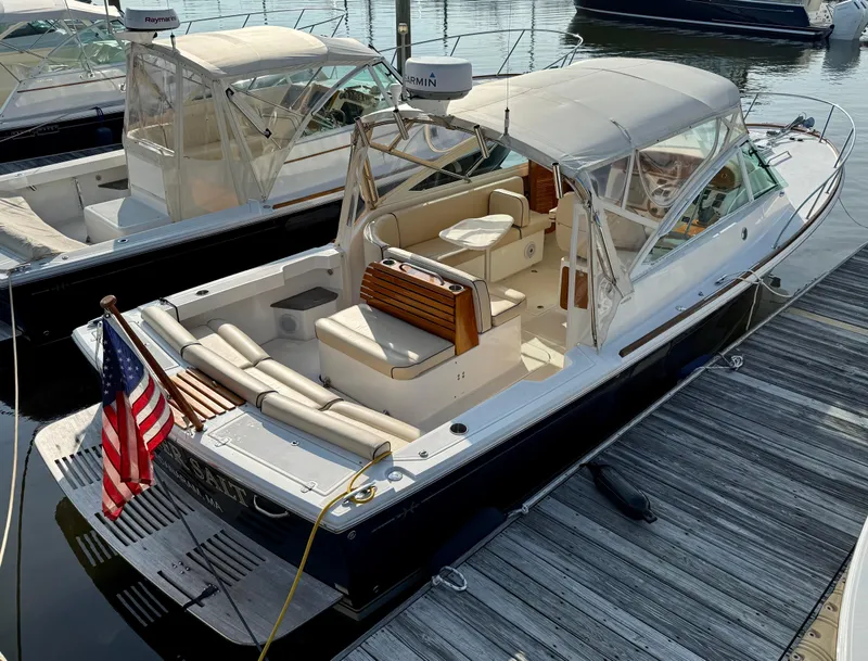 Slide: The Image of 2009 Hunt Yachts Harrier 29 docked, featuring elegant seating and American flag. - 7