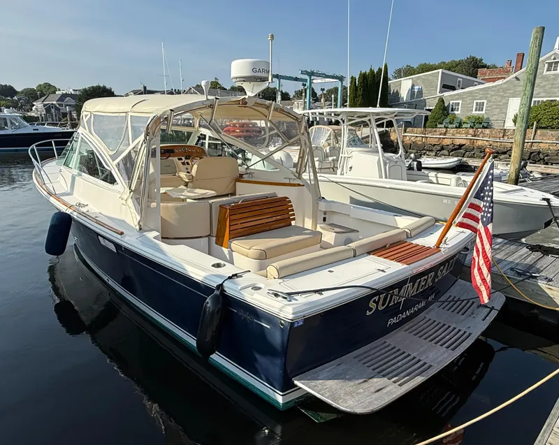 Slide: The Image of 2009 Hunt Yachts Harrier 29 docked, featuring elegant design and American flag. - 8