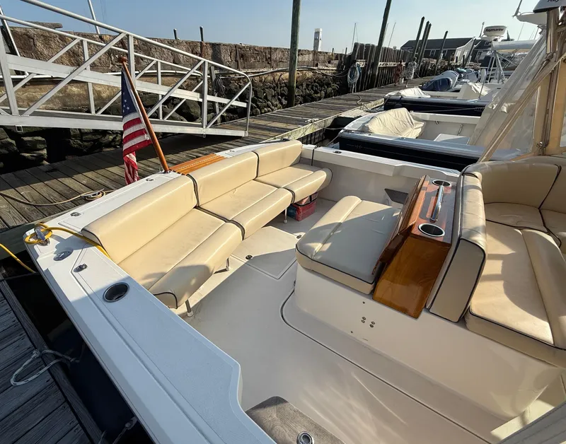 Slide: The Image of 2009 Hunt Yachts Harrier 29 with beige seating and American flag at dock. - 12