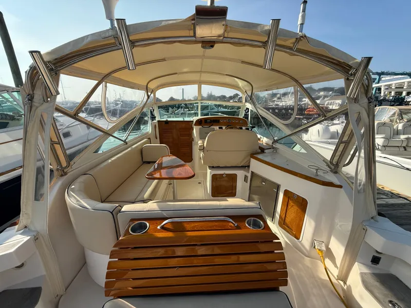 Slide: The Image of 2009 Hunt Yachts Harrier 29 interior with elegant seating and wooden accents at a marina. - 14