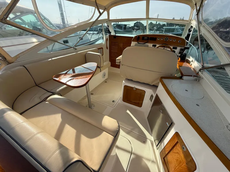 Slide: The Image of 2009 Hunt Yachts Harrier 29 interior with beige seating, wooden accents, and helm station. - 15