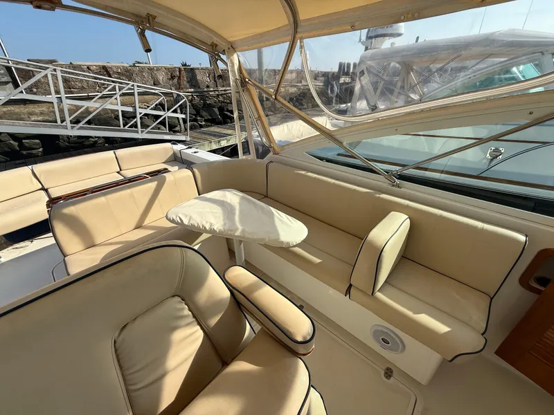 Slide: The Image of 2009 Hunt Yachts Harrier 29 interior with beige seating and table, docked at marina. - 19