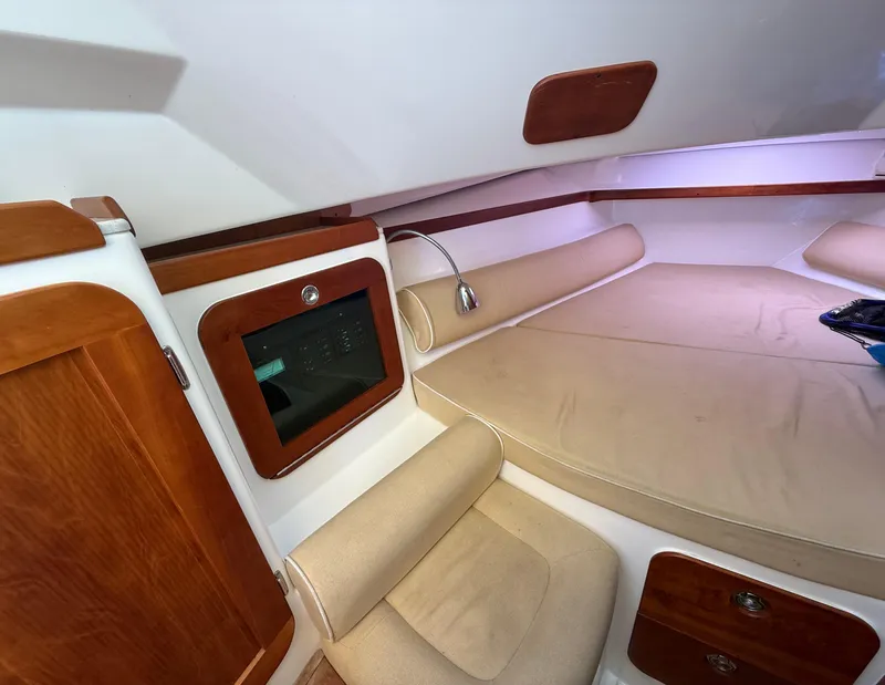 Slide: The Image of 2009 Hunt Yachts Harrier 29 cabin interior with beige seating and wooden accents. - 24