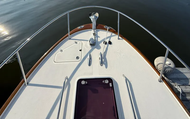 Slide: The Image of 2009 Hunt Yachts Harrier 29 bow with railing and anchor, docked on calm water. - 9