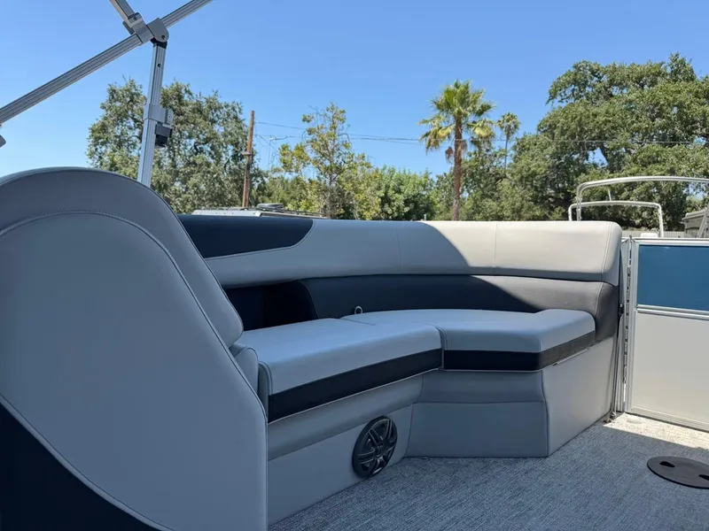 Slide: The Image of 2025 South Bay 222 LE pontoon boat interior with gray seating and scenic background. - 13