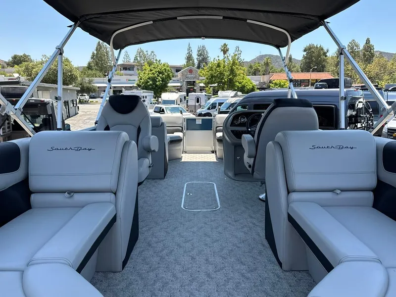 Slide: The Image of 2025 South Bay 222 LE pontoon boat interior with plush seating and modern dashboard. - 14