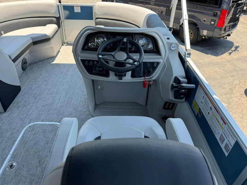 Slide: The Image of 2025 South Bay 222 LE boat interior with steering console and seating area. - 17