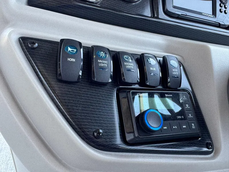 Slide: The Image of Control panel of 2025 South Bay 222 LE boat with switches and audio system. - 22