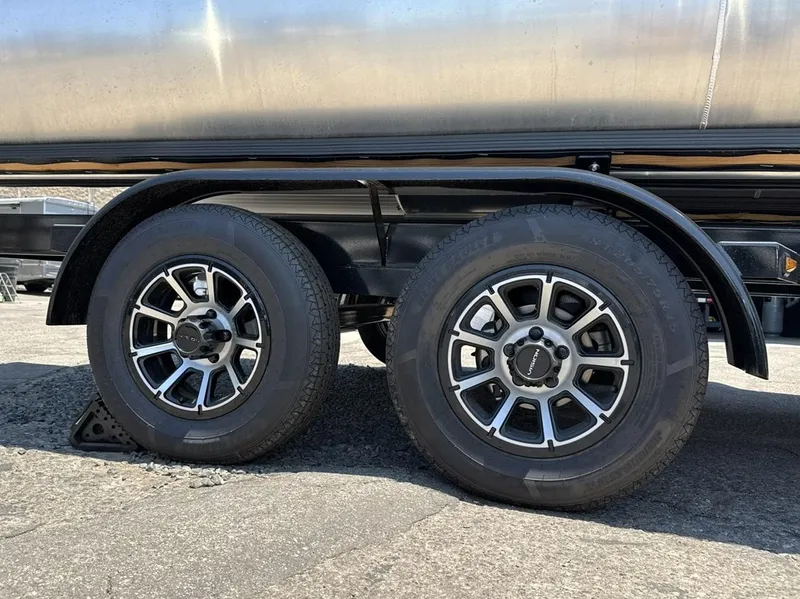 Slide: The Image of 2025 South Bay 222 LE trailer wheels on pavement, showcasing dual tires and alloy rims. - 24