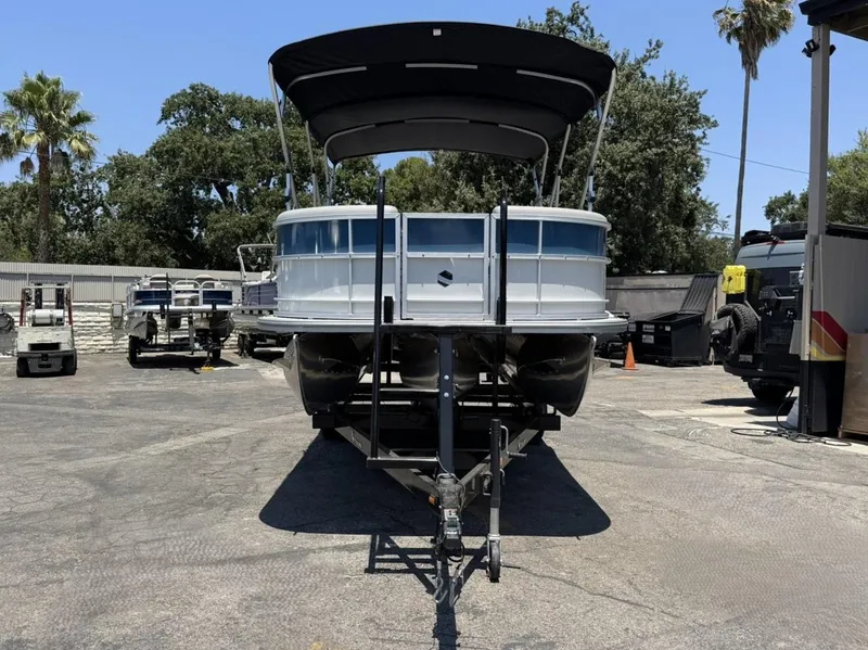 Slide: The Image of 2025 South Bay 222 LE pontoon boat on trailer in outdoor setting. - 31