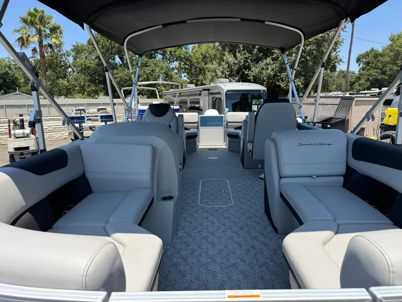 Slide: The Image of 2025 South Bay 222 LE pontoon boat interior with plush seating and canopy. - 4