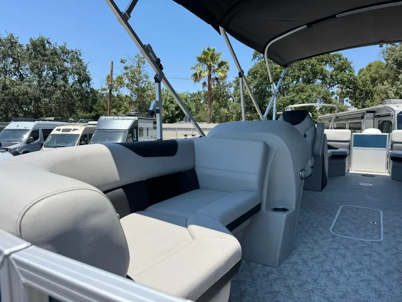 Slide: The Image of 2025 South Bay 222 LE pontoon boat interior with plush seating and canopy. - 7