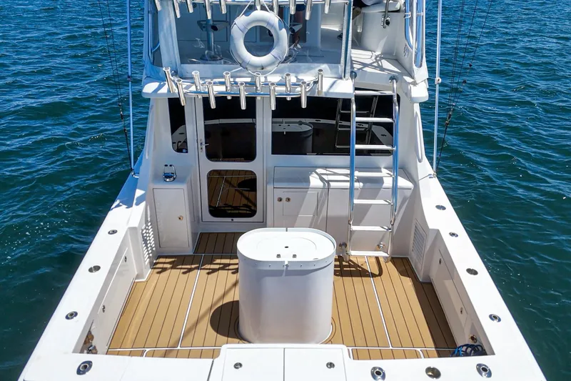 Slide: The Image of 2009 Egg Harbor 37 SportYacht deck with fishing equipment, ladder, and ocean backdrop. - 19
