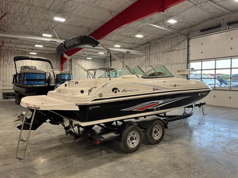 Slide: The Image of 2011 Hurricane SD217 boat in a showroom, featuring sleek design and dual-axle trailer. - 8