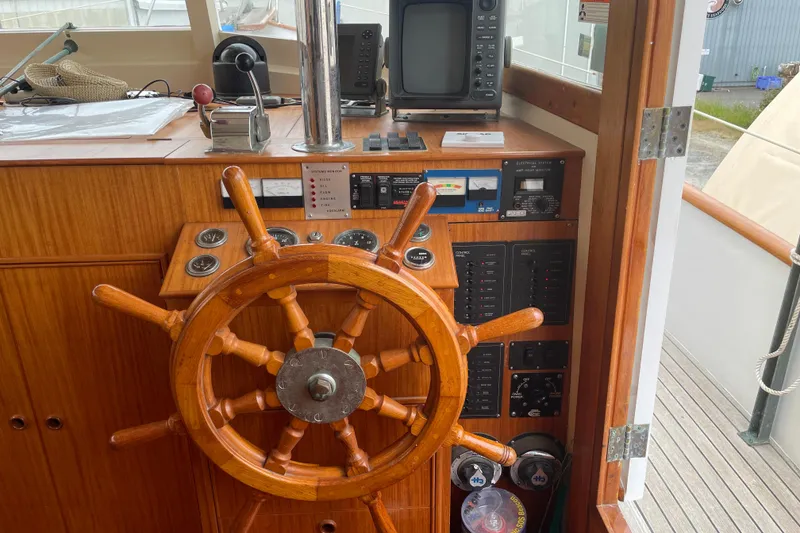 Slide: The Image of 1964 Grand Banks 42 Classic helm with wooden wheel and navigation instruments. - 15