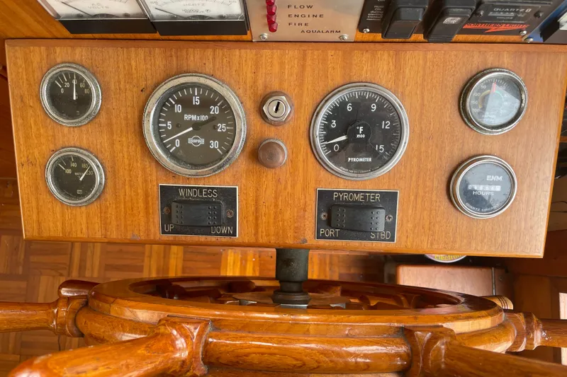 Slide: The Image of Vintage 1964 Grand Banks 42 Classic boat dashboard with gauges and wooden steering wheel. - 37