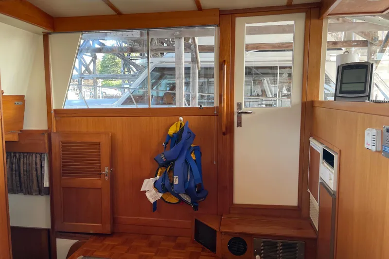 Slide: The Image of Interior of 1964 Grand Banks 42 Classic boat with wooden paneling and life jackets. - 48