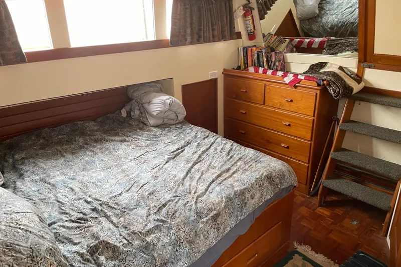 Slide: The Image of Cozy bedroom in a 1964 Grand Banks 42 Classic yacht with wooden furniture and bedding. - 53