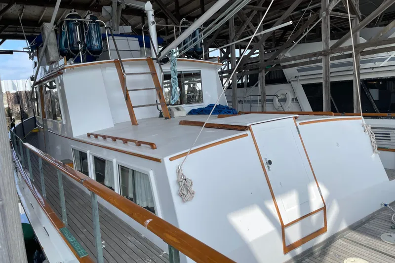 Slide: The Image of 1964 Grand Banks 42 Classic yacht docked in a covered marina, showcasing wooden details. - 6