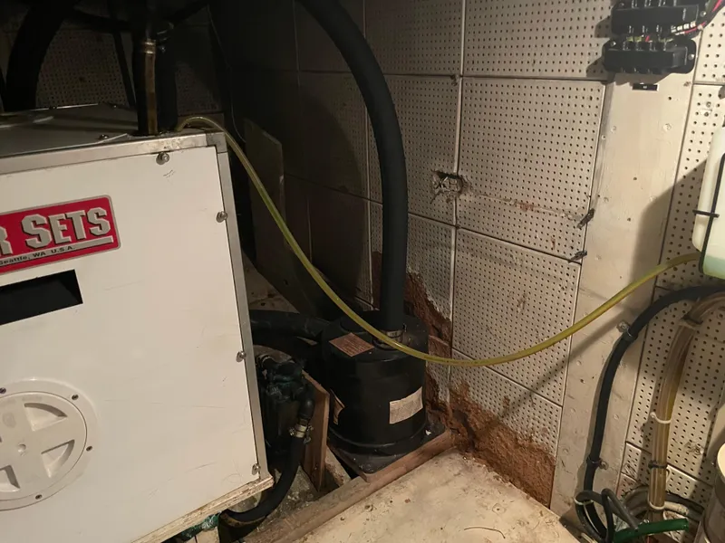 Slide: The Image of Engine room of a 1964 Grand Banks 42 Classic boat, featuring machinery and wiring. - 63