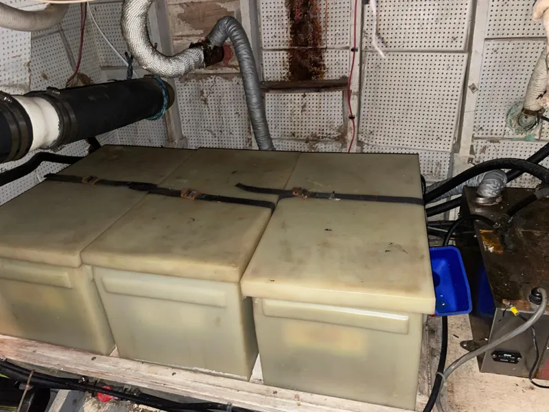 Slide: The Image of Engine room of a 1964 Grand Banks 42 Classic with storage containers and piping. - 71