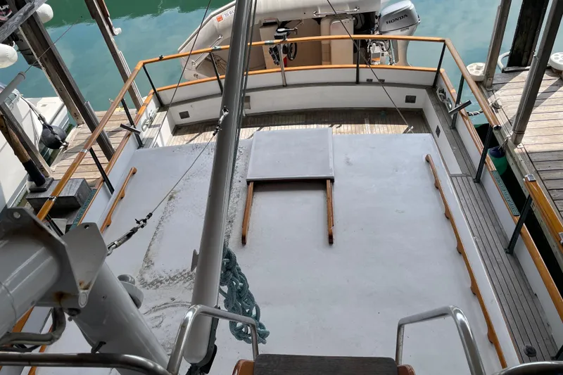 Slide: The Image of 1964 Grand Banks 42 Classic yacht deck with wooden railings and docked at marina. - 8
